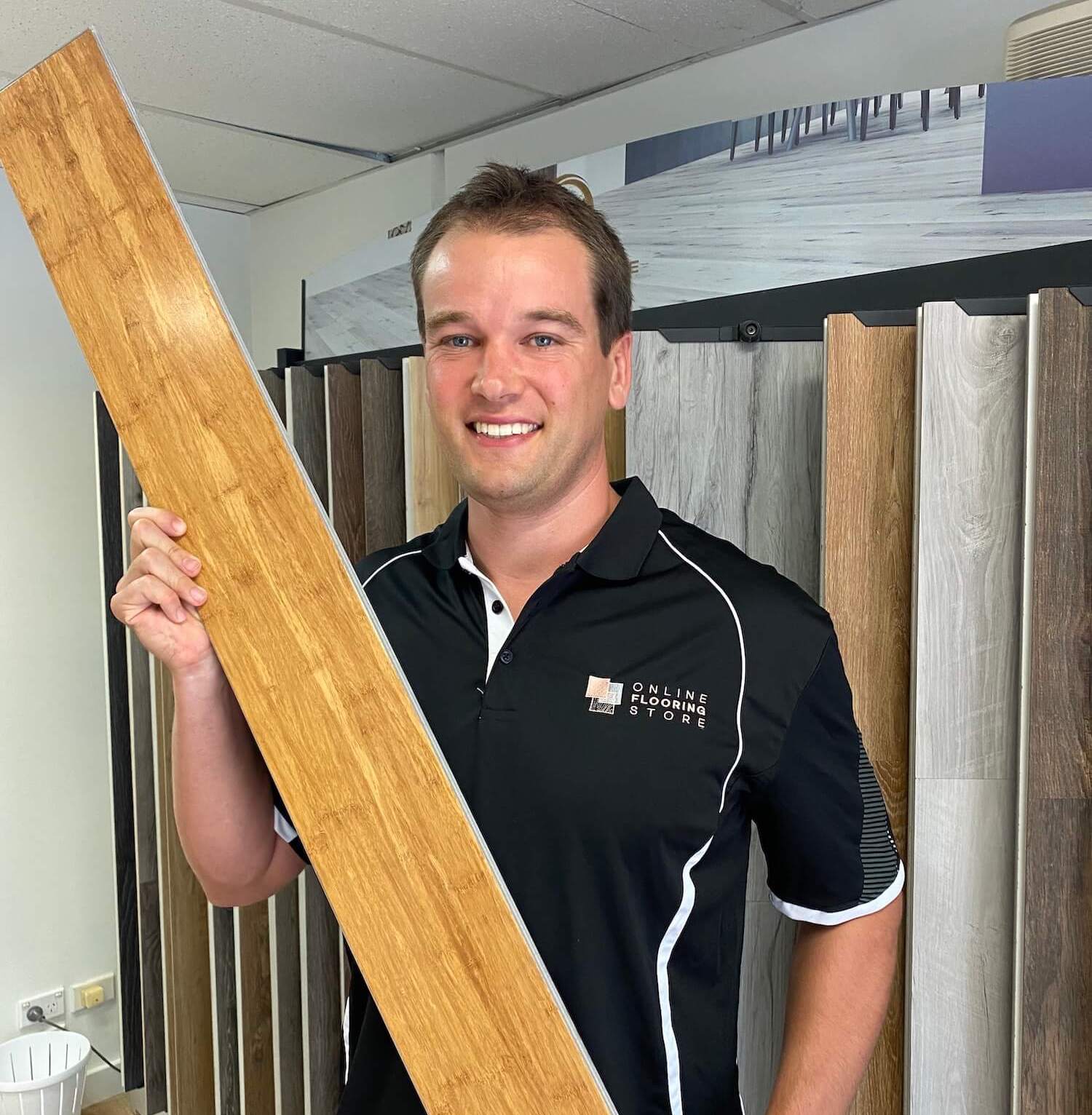 Brad holding up a wooden floorboard for display.