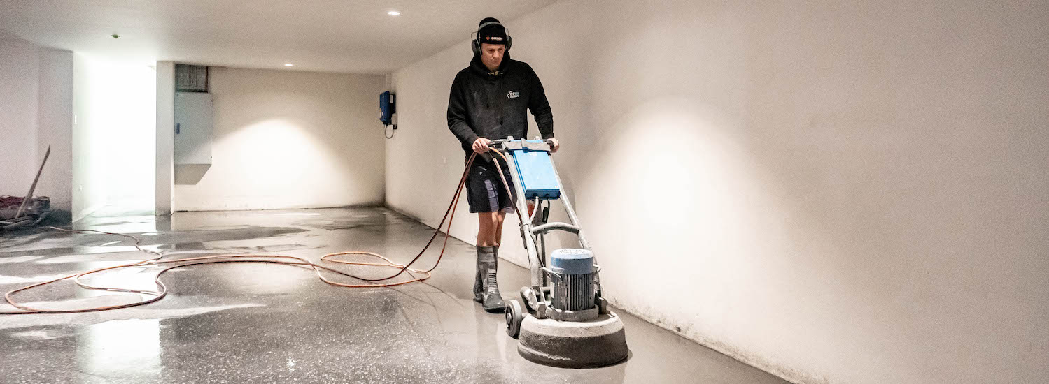 Worker polishing floors in building site