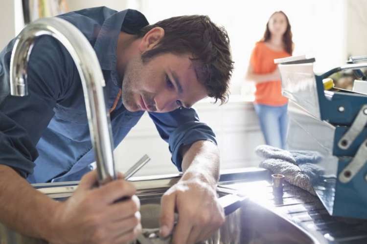 Plumber working on faucet.