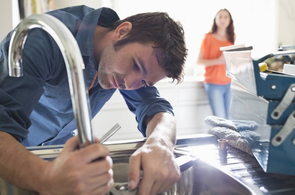 Plumber working on faucet.