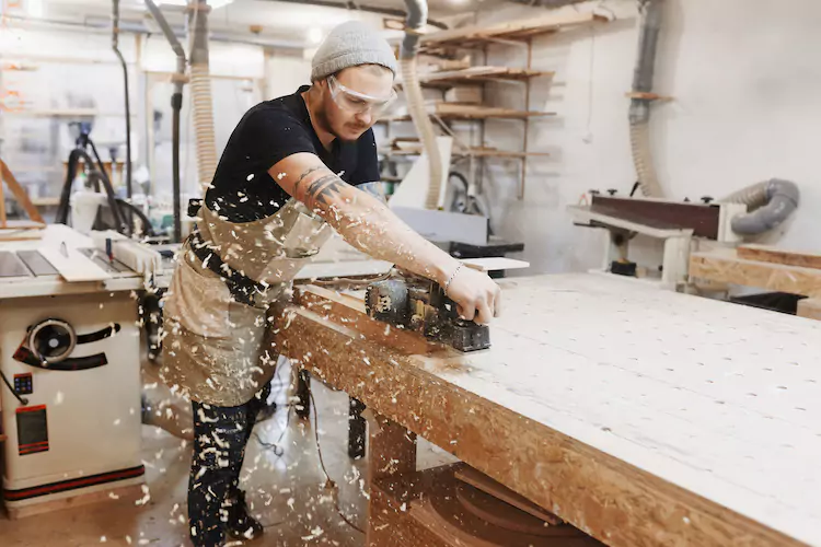 carpenter-cutting Carpenter cutting with a saw
