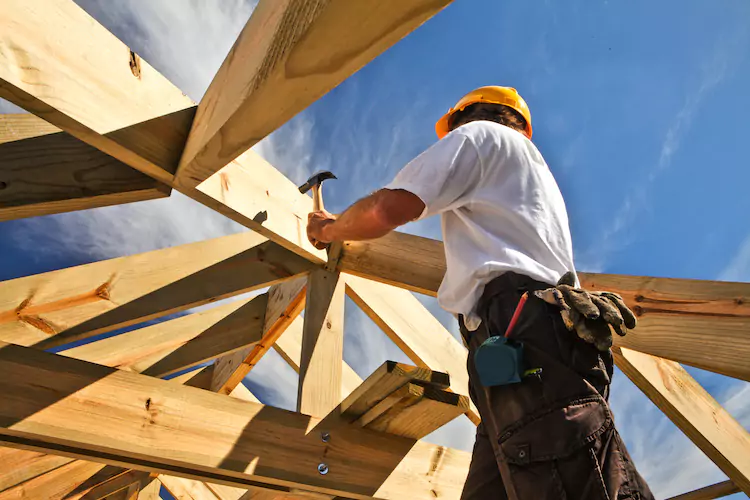 Carpenter hammering a nail into a roof