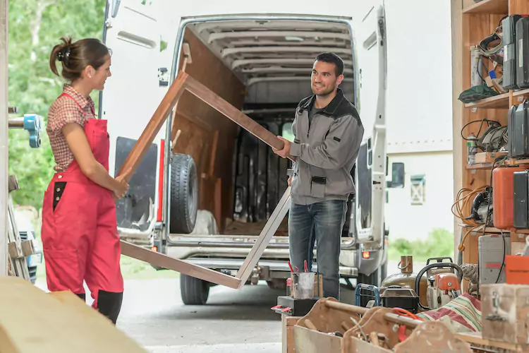 Carpenters unloading their van in their workshop