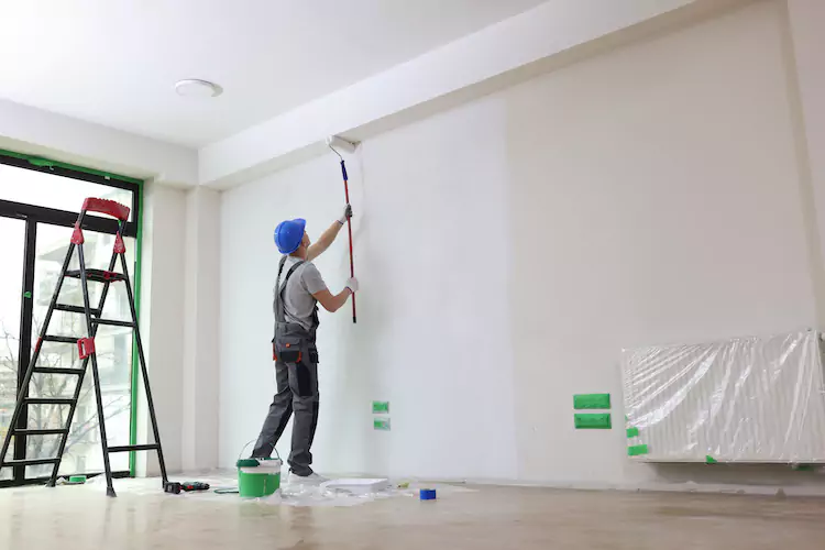 Painter using a roller on the ceiling