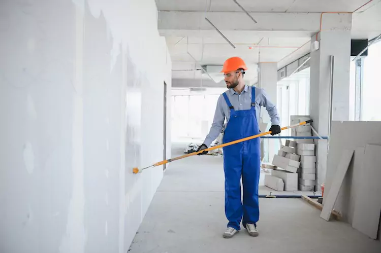 painters-insurance-hardhat Painter wearing a hardhat using a roller on a wall