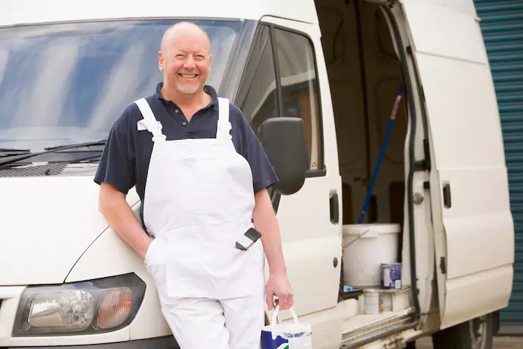 painters-insurance-van Painter leaning on his commercial vehicle with a paint bucket in his hand