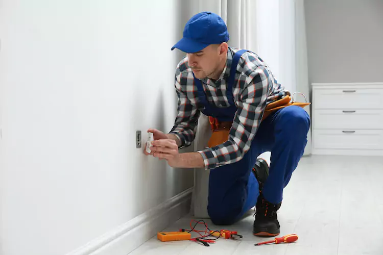 Insured electrician opening a socket in a residential home