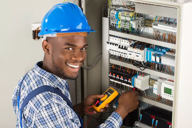 Electrician smiling while working on a fuse box
