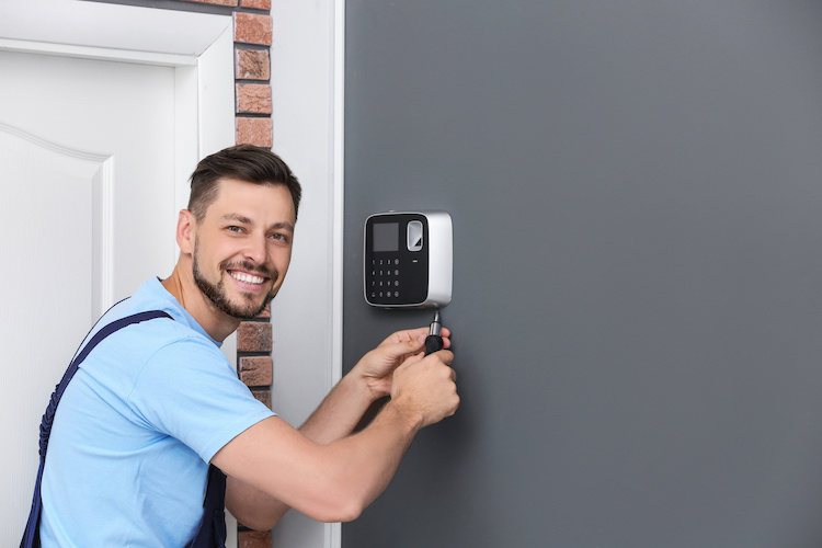 Male technician installing alarm system indoors