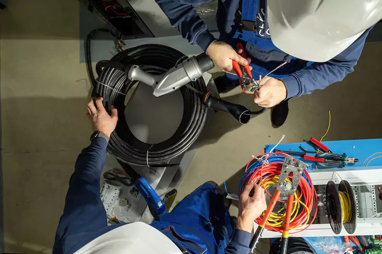 EV charger installers holding a cable