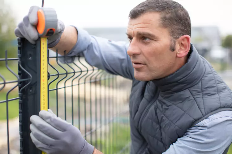 Insured fencer installing a metal fence
