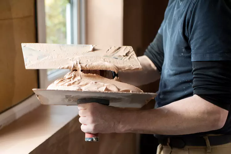 Insured plasterer plastering a windowsill