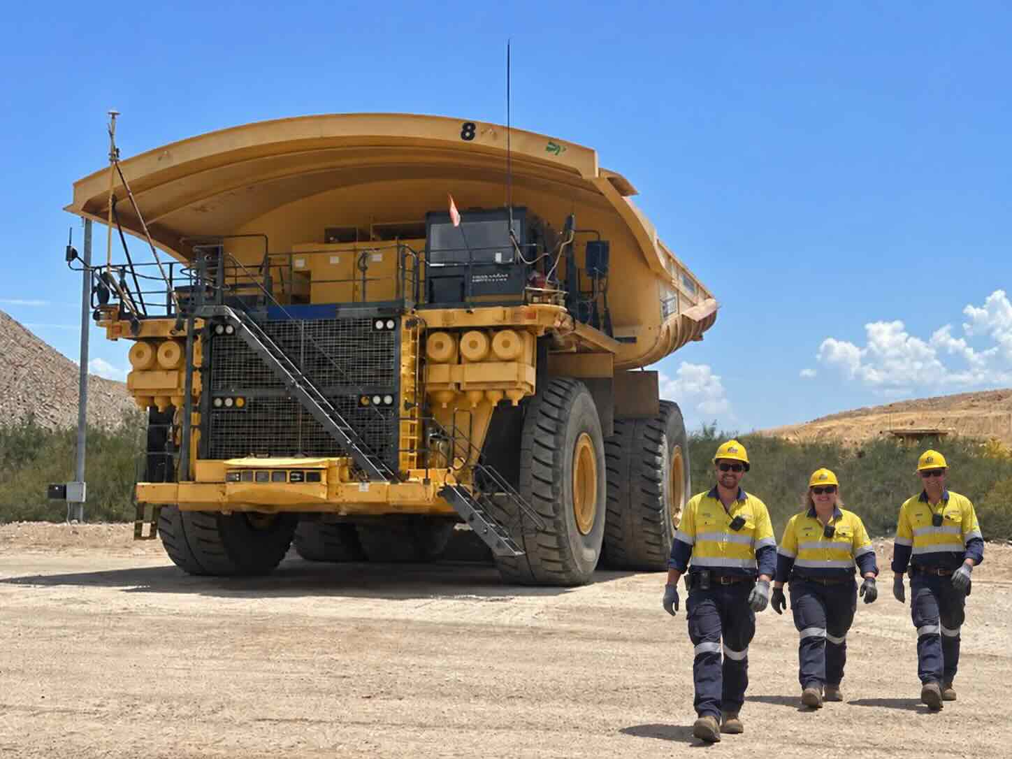 Plant and machinery operaters standing beside heavy machinery